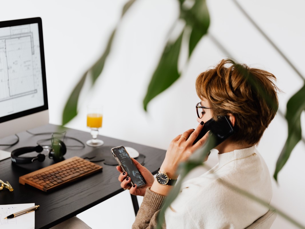 Multitaskende vrouw achter bureau