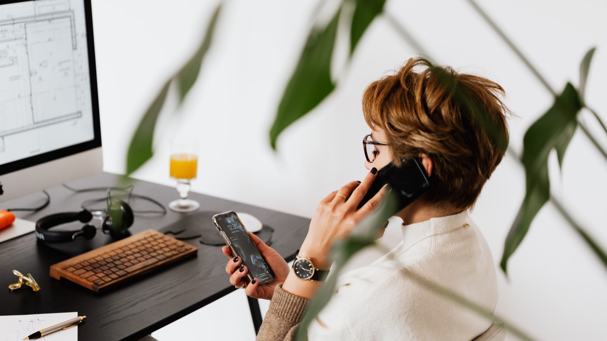 Multitaskende vrouw achter bureau